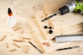 Wooden dowel joint pins drill glue wood planks safety glasses cordless screwdriver and tools spruce background. Carpenter industry