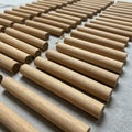 Wooden dowels are neatly arranged in parallel rows on a textured fabric surface. Each Royalty Free Stock Photo