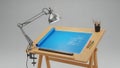 A wooden drafting table with a blue paper and drawing tools Royalty Free Stock Photo