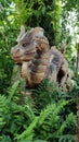 Wooden dragon structure surrounded by green plants and trees.