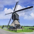 Wooden drainage windmill with a water-wheel against blue sky, The netherlands