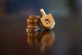 Wooden Dreidel Resting on Stack of Coins Royalty Free Stock Photo