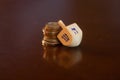 Wooden Dreidel Resting on Stack of Coins Royalty Free Stock Photo