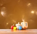 Wooden dreidels for hanukkah and glitter golden lights background Royalty Free Stock Photo