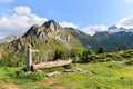 A wooden drinking trough with water spring on the high Alps mountains with Lobhoerner Peak Royalty Free Stock Photo