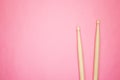 Wooden drumsticks on pink back