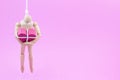 Wooden dummy chaining themselves to the paper box red heart shape on pink background with copy space for your