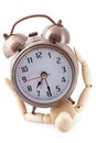 Wooden dummy crushed by old-styled alarm clock. Royalty Free Stock Photo