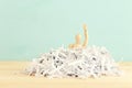 Wooden dummy drowning in shredded paper Royalty Free Stock Photo