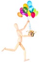 Wooden Dummy holding gift and flying balloons Royalty Free Stock Photo