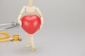 Wooden dummy holding red heart have blur stethoscope white background Royalty Free Stock Photo