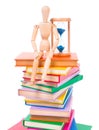 Wooden dummy puppet sitting on books Royalty Free Stock Photo