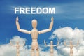 Wooden dummy puppet on sky background with word FREEDOM Royalty Free Stock Photo