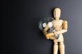 Wooden dummy toy and light bulb on black background with copy sp Royalty Free Stock Photo