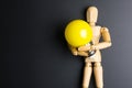 Wooden dummy toy and light bulb on black background with copy sp Royalty Free Stock Photo