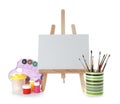 Wooden easel with blank canvas board and painting tools for children Royalty Free Stock Photo