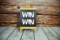 Win-Win text written on blackboard with easel standing on wooden floor Royalty Free Stock Photo