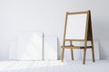 Wooden easel standing in an empty white room Royalty Free Stock Photo