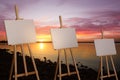 Wooden easels with blank canvases near river at sunset Royalty Free Stock Photo