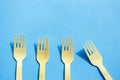 Wooden bamboo cutlery on bright blue background