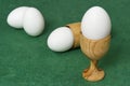 Wooden egg cup holder with white egg on green table Royalty Free Stock Photo