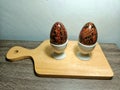 wooden egg display on a table with an Indonesian batik motif. Placed on a wooden table