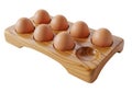 Wooden egg holder with seven brown eggs, featuring a smooth, polished finish. The Royalty Free Stock Photo