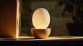 A wooden egg-shaped lamp with a white egg inside sits on a wooden table. Royalty Free Stock Photo