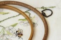 Wooden embroidery hoop with fragment of colorful cross-stitch embroidery close-up, summer flower ornament Royalty Free Stock Photo