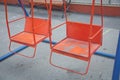 Wooden and Empty red and blue chain swings in children playground . chain swings hanging in garden . Childs swing in a park