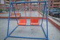 Wooden and Empty red and blue chain swings in children playground . chain swings hanging in garden . Childs swing in a park