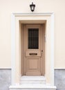 Wooden entrance door, beige color wall background, residential building in old town of Plaka, Athens Greece Royalty Free Stock Photo