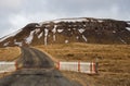 Wooden entrance gate, empty road and snowy mountain in Iceland