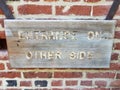 Wooden entrance on other side sign on red bricks Royalty Free Stock Photo