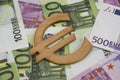 Wooden euro sign symbol on one and five hundred euro banknotes