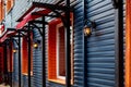 Wooden facade of building with retro lanterns illuminating the house.