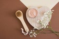 wooden face massage brush, blank mock up aluminum open cosmetic cream jar with pink clay mask and lily flowers Royalty Free Stock Photo