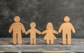 Wooden family figures hold hands on grey background,concept,support and care,parents,children Royalty Free Stock Photo