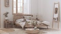 Wooden farmhouse bedroom in boho chic style. Rattan bed and furniture in white and bleached wood tones. Country wallpaper, vintage
