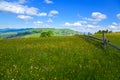 Wooden fence across mountain pasture, blue sky with clouds. Ukraine, carpathians. Royalty Free Stock Photo