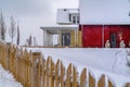 Wooden fence against snow and homes in winter Royalty Free Stock Photo