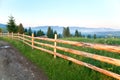 Wooden fence along a mountain meadow in the morning. Carpathians. Royalty Free Stock Photo