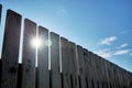 Wooden fence on a background of blue sky with clouds on a sunny day. Rustic wooden plank background Royalty Free Stock Photo