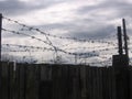 Wooden fence with barbed wire forbidden territory of the prison Royalty Free Stock Photo