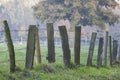 A wooden fence with barbed wire standing in a field Royalty Free Stock Photo