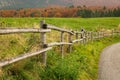 Wooden fence borders a mountain pasture, rural path Royalty Free Stock Photo