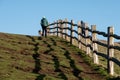 Wooden fence at cliff edge, with shadow on the grass, photographed at Hope Gap, Seaford, East Sussex UK