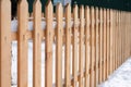 Wooden fence covered with snow around garden in winter time Royalty Free Stock Photo