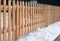 Wooden fence covered with snow around garden in winter time Royalty Free Stock Photo