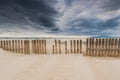 wooden fence on dunes and beach at storm weather Royalty Free Stock Photo